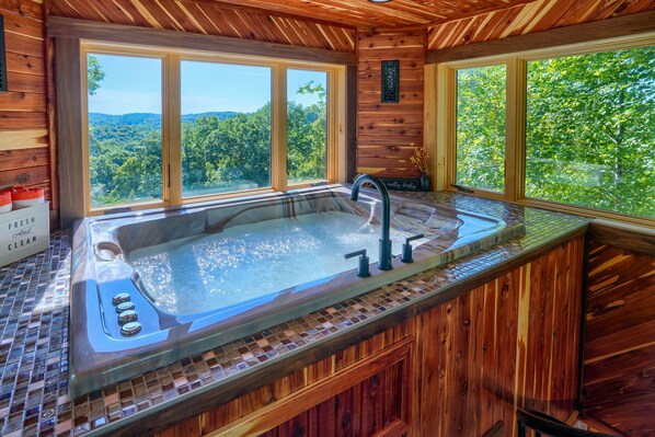 A wooden cabin with a large window, a hot tub, and a sign reading 'FRESH And CLEAN'. - Soaring Eagle Luxury Treehouse (Logan)