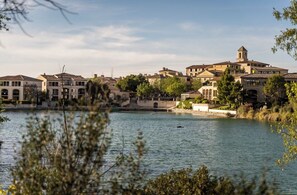 Surrounded by lush greenery, this lakeside retreat offers serene views of the water from its Mediterranean-inspired buildings.