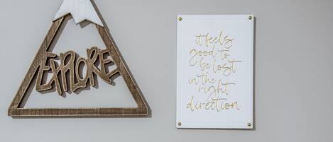 Un triangle en bois sur lequel est inscrit le mot « EXPLORE » et un tableau blanc sur lequel figure un message motivant.