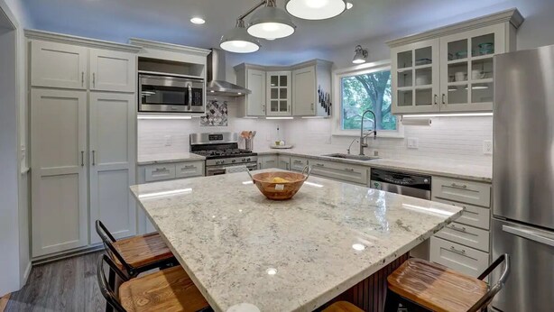 A modern kitchen with white cabinetry, a large island with a bowl, stainless steel appliances, and pendant lighting. - Elegant Space–Premium Kitchen–Spacious & Ideal for Gathering w/ Friends & Family (Middleton)
