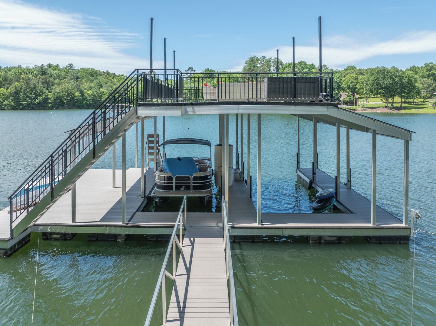 A floating dock with a covered seating area and a boat.