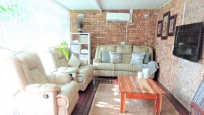 A cozy living room with a sofa, armchairs, and a coffee table. - Spacious holiday home in cozy complex. Walking distance from the nature reserve. (KZN)