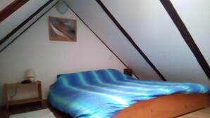 A small, sloped-roofed room with a single bed, a nightstand, a lamp, and a painting on the wall. - No 2 Old Town Apts is in the centre of Bohinjska Bistrica, close to amenities. (Radovljica)