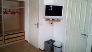 A room with a wardrobe, a television mounted on the wall, and two trash bins. - No 2 Old Town Apts is in the centre of Bohinjska Bistrica, close to amenities. (Radovljica)