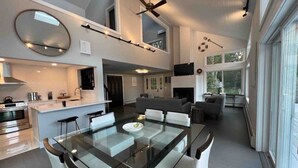 Uma cozinha moderna com mesa de jantar de vidro, eletrodomésticos embutidos e uma ilha grande.
