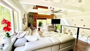 A modern living room with a large sectional sofa, a flat-screen TV, and a ceiling fan. - Luxury Private Estate Mins to Winery /Brewery (Leesburg)