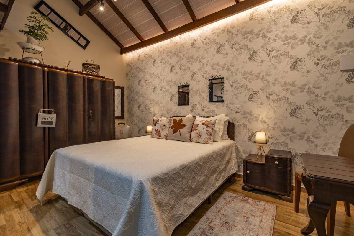 Une chambre à coucher avec un grand lit, une armoire en bois et une petite table avec une lampe.