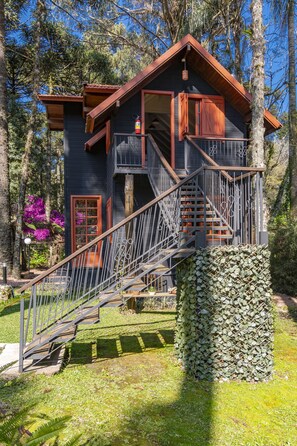 A cabin with a wooden exterior, a balcony, and a staircase leading to an upper level. - Pousada Vila 505 (Canela)