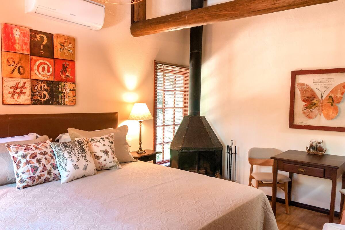 Une chambre à coucher avec un lit, une table et une cheminée.