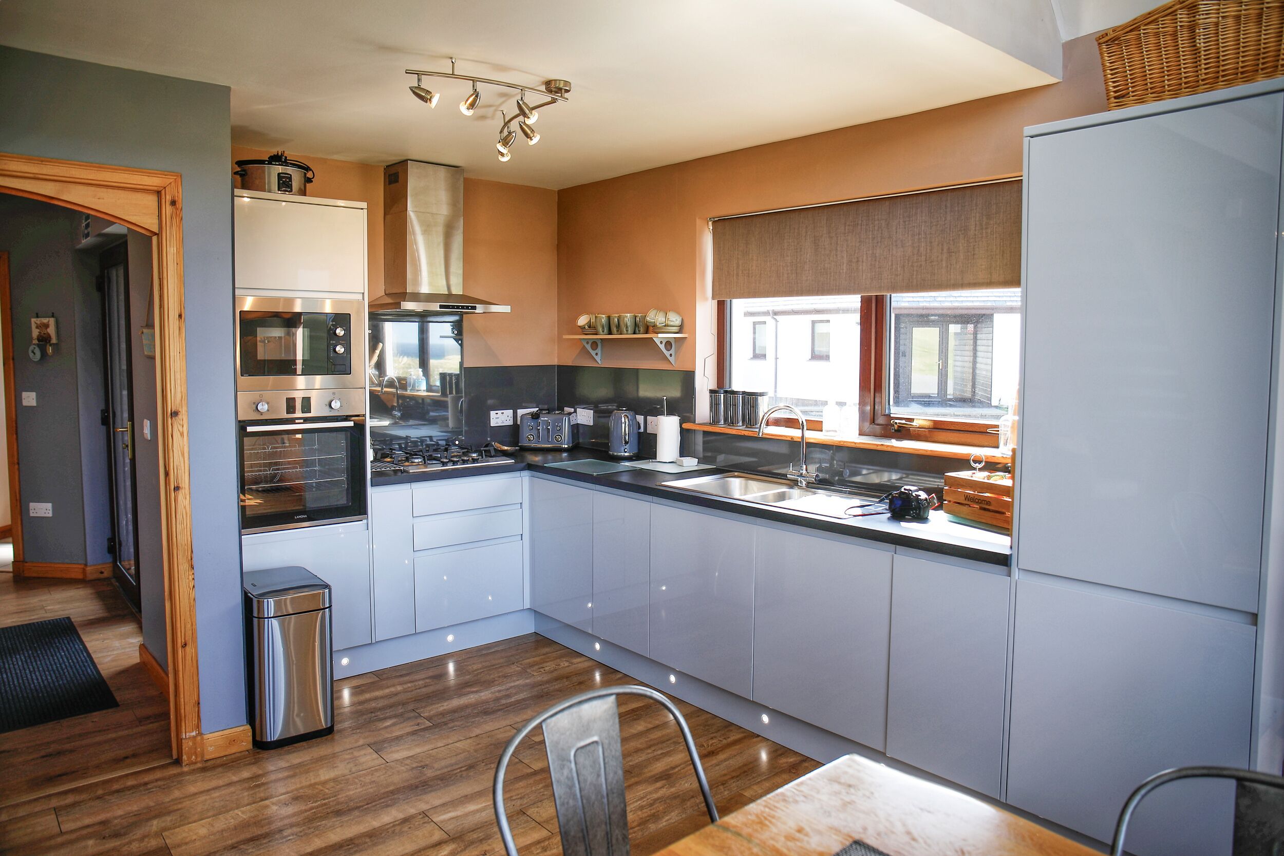 A modern kitchen with stainless steel appliances, a large island, and a window providing natural light.