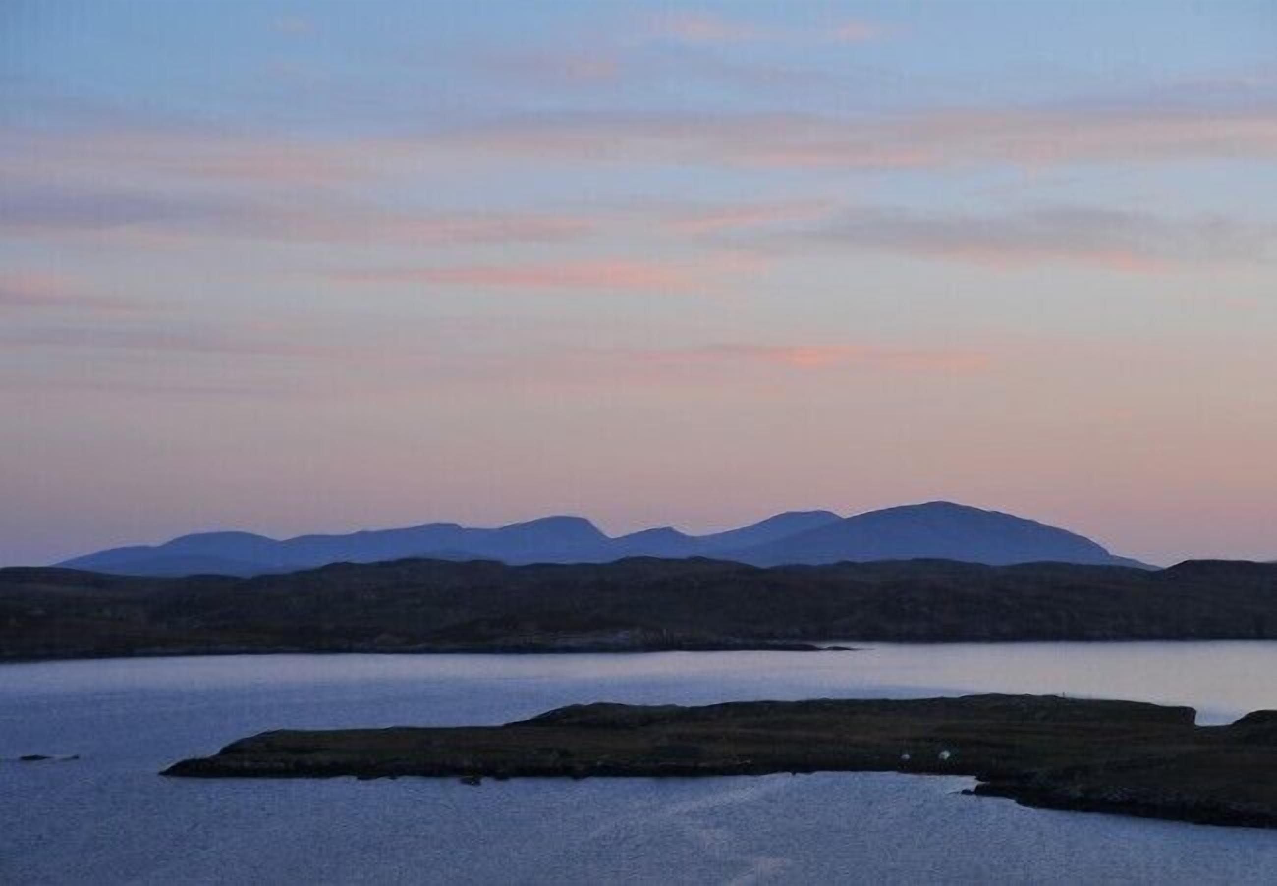A panoramic view of a lake with mountains in the background.