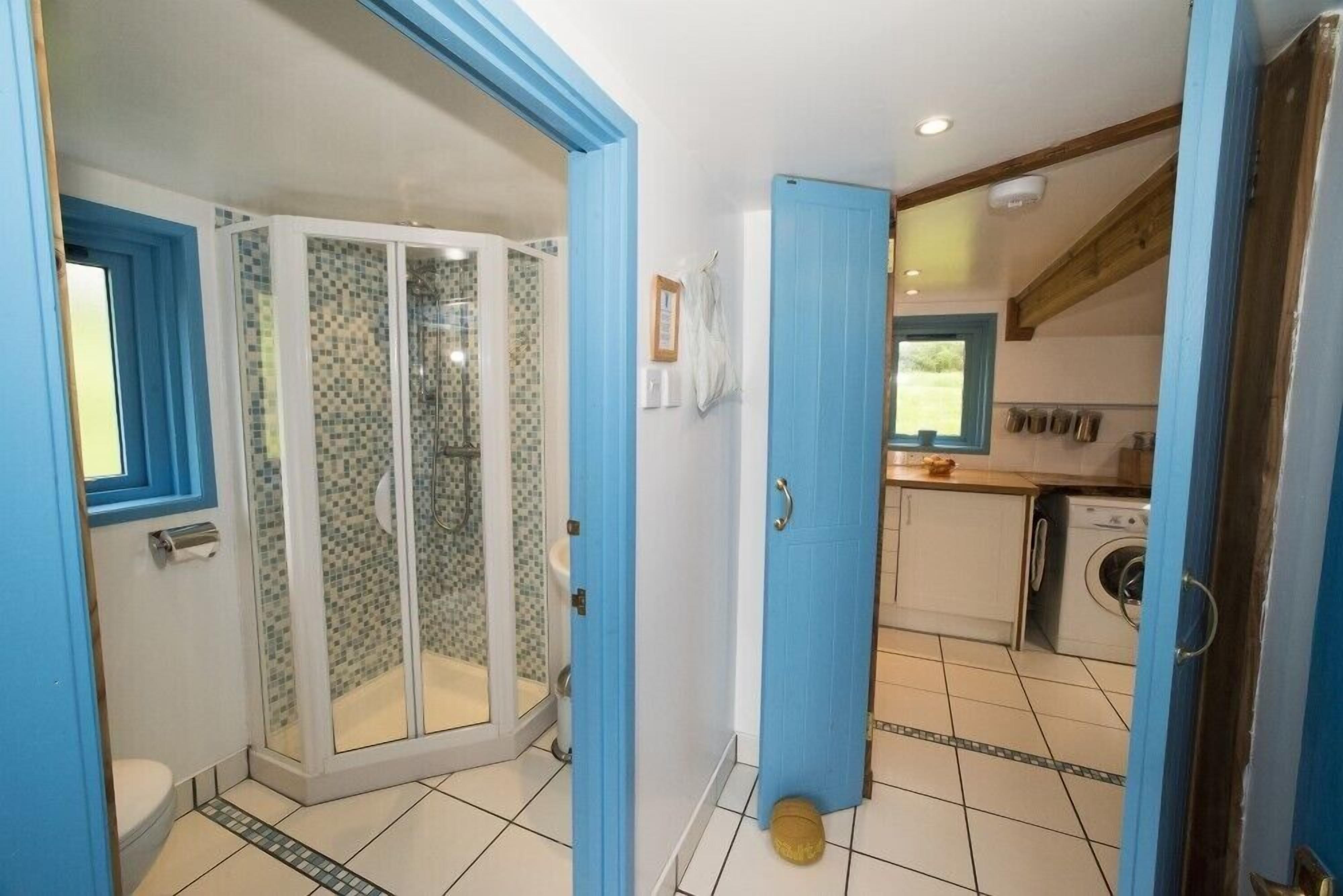 Een badkamer met een douchecabine van glas en een toilet.