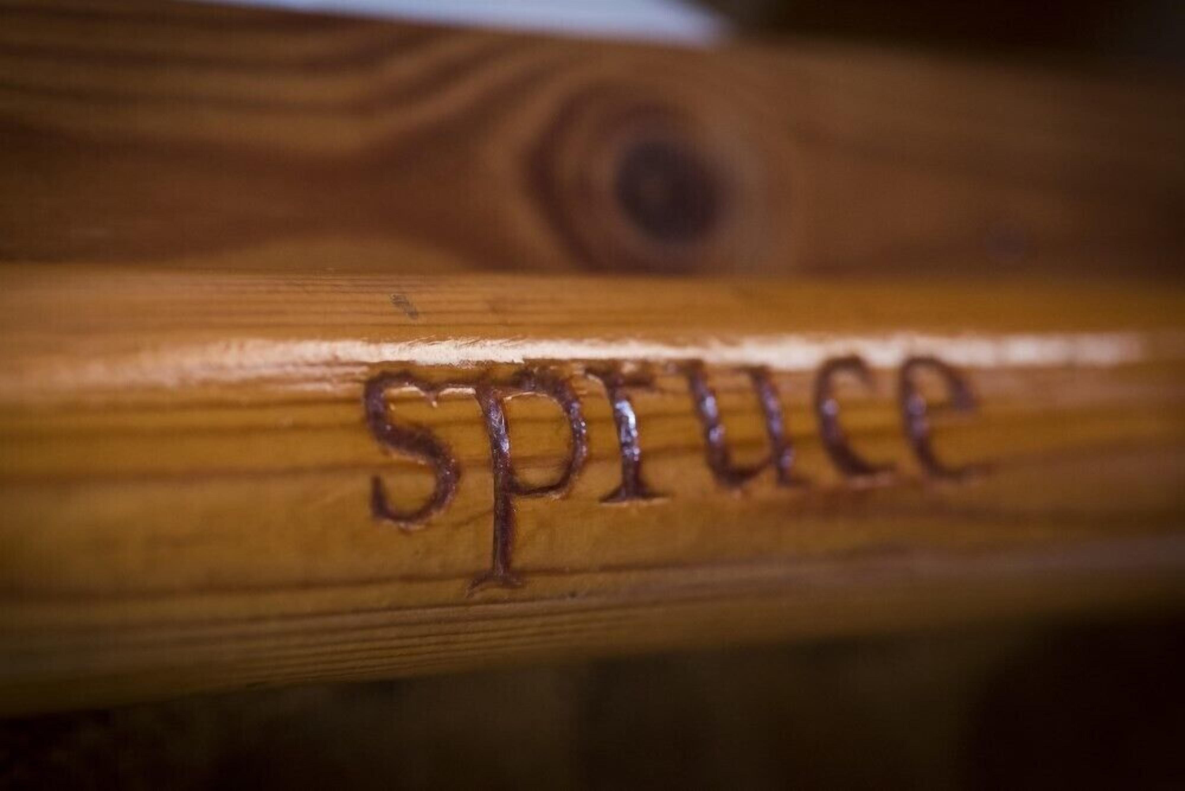 Superficie de madera con la palabra "spruce" grabada.