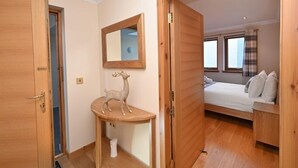 Une chambre à coucher avec un lit, une table de chevet et un miroir au mur.