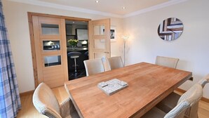 Un coin repas comprenant une table en bois, six chaises et un élément décoratif mural.