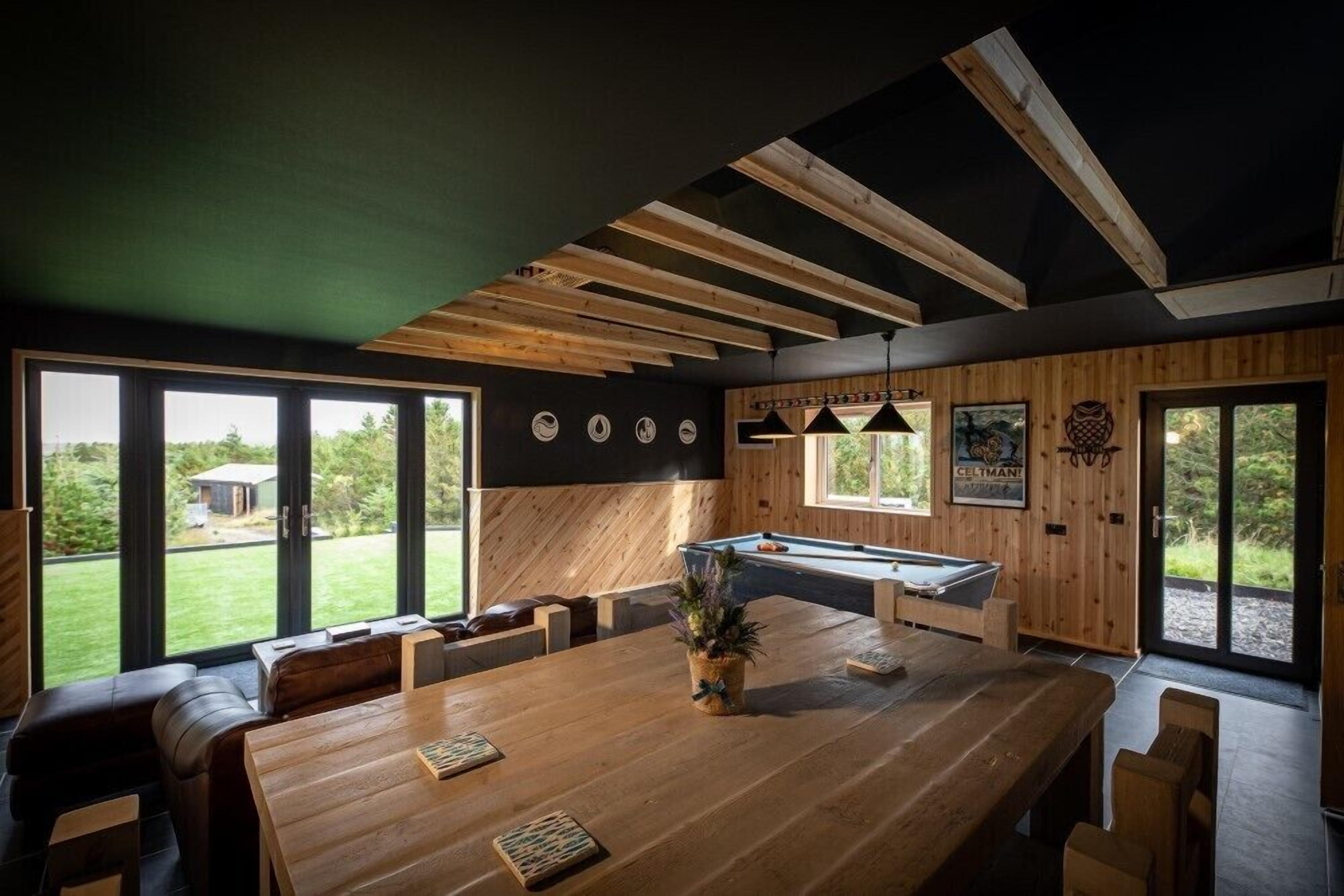 Une cuisine moderne avec une table en bois, des sièges et une table de billard.