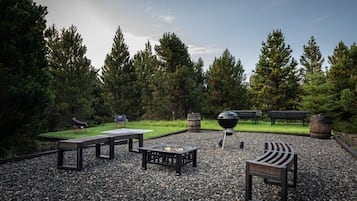 Un espacio al aire libre con bancos, una fogata y una parrilla.