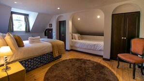 A bedroom with two beds, a chair, a lamp, and a window. - Cortes House (Fraserburgh)