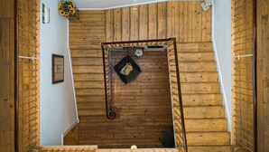 A wooden interior with a staircase, a framed picture, and a small statue. - Cortes House (Fraserburgh)