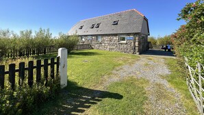 A stone building with a sign reading "Country Cottage." - Canach Cottage (South Uist)