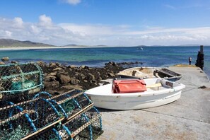A small boat docked at a pier with fishing traps nearby.