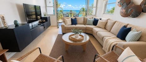 Ein modernes Wohnzimmer mit einer großen Couch, einem Couchtisch und Korbstühlen.