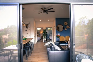 Un espacio de sala-comedor con mesa, asientos y ventilador de techo.