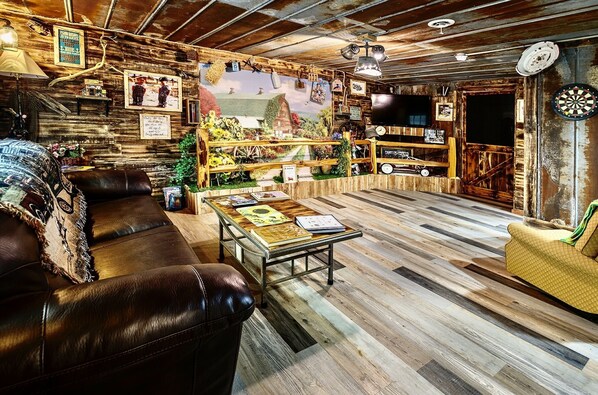 Relax in this inviting living room with a leather sofa, armchair, and bookshelf.