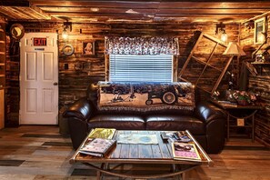 Relax in this rustic retreat with a leather sofa, wooden coffee table, and vintage decor.
