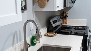 A kitchen with a stainless steel sink, a microwave, and a stove. - Madrona's Cottage B- Your Central Hub to Charleston! 5 Min From Airport (North Charleston)