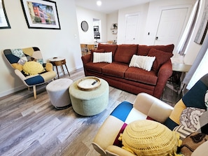 Relax in this inviting space with a comfortable sofa, armchair, and dining area.