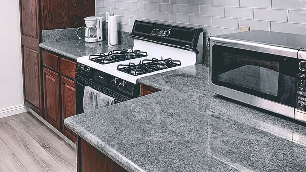 Une cuisine moderne équipée d’une cuisinière à gaz, d’un four à micro-ondes et d’un four encastré.