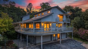 Una casa a più piani con un balcone, un garage e un vialetto.