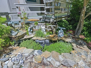 A garden with a pond, stone structures, and a statue.