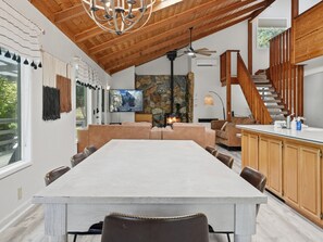 A spacious living area with a fireplace, a dining table, and a kitchen counter.