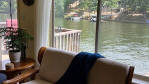A room with a view of a river, a potted plant, and a wooden chair. - Adorable Lake Getaway (Hot Springs)