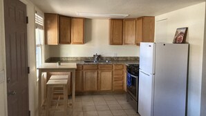 A kitchen with wooden cabinets, a white refrigerator, a stove, and a sink. - Private 1br near downtown Flagstaff, NAU, Hospital (Flagstaff)