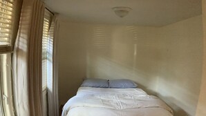 A bedroom with a wooden floor, a bed with white bedding, and a window with curtains. - Private 1br near downtown Flagstaff, NAU, Hospital (Flagstaff)