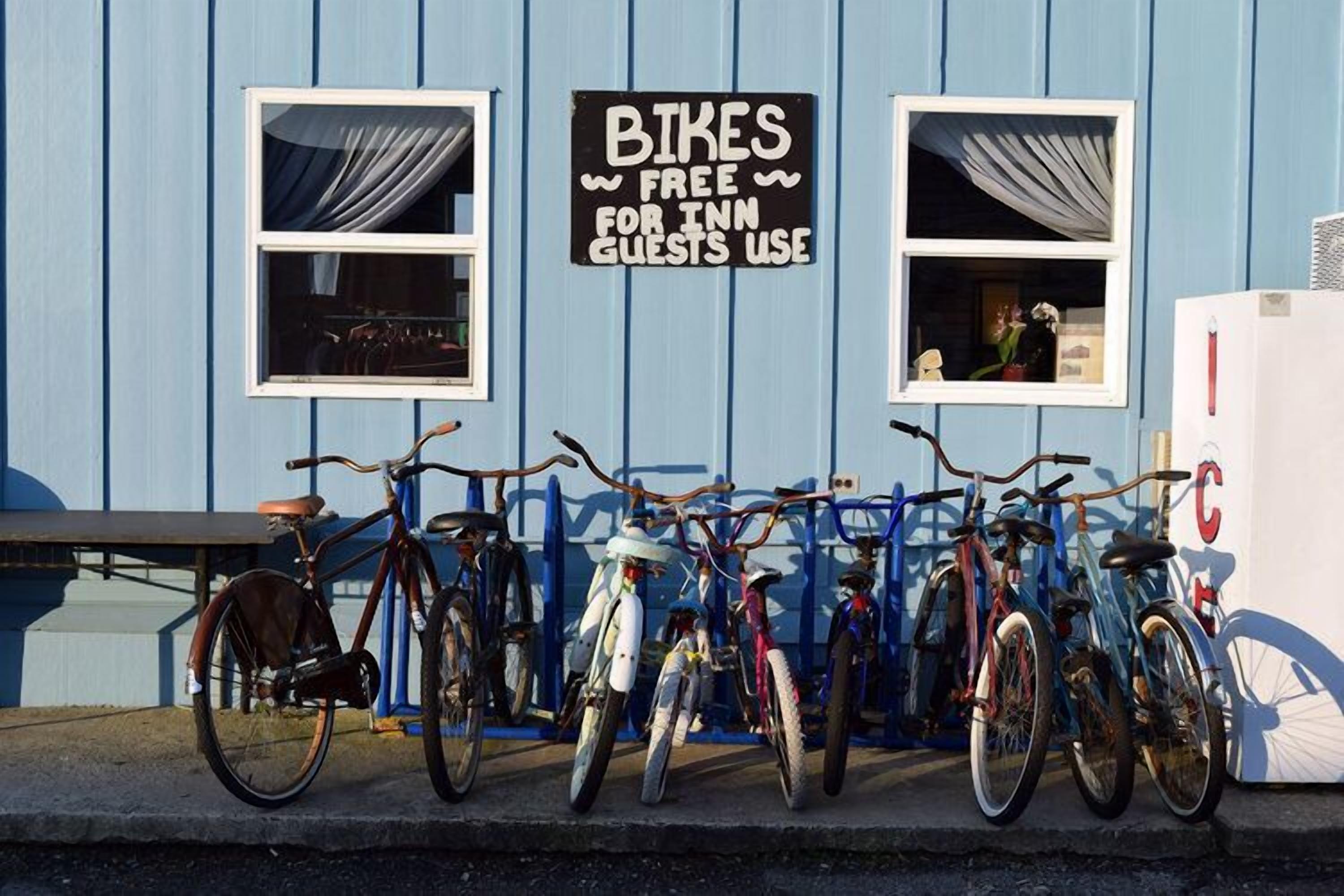 Een blauw gebouw met een bord waarop aangeboden wordt: gratis fietsen voor gasten.