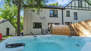 A hot tub in a backyard with a house in the background.