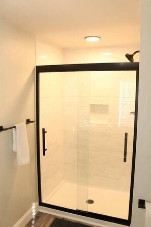 Bathtub, hair dryer, towels, toilet paper