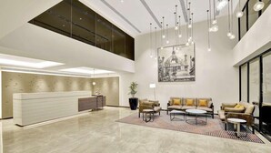 A spacious lobby with a reception desk, seating area, and a large window. - Park Inn by Radisson Surat (Surat)