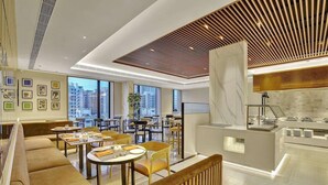 A modern hotel lobby with seating areas, a reception desk, and large windows offering city views. - Park Inn by Radisson Surat (Surat)