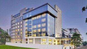 A modern hotel with a glass facade, multiple floors, and a flat roof. - Park Inn by Radisson Surat (Surat)