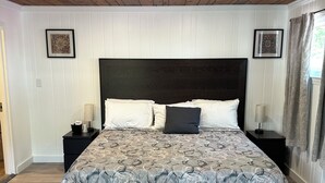 A bedroom with a large bed, two nightstands, a dark headboard, and a wooden ceiling. - New Hope Lodge (New Hope)