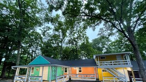 A two-story house with a green roof, orange walls, and a yellow upper level. - New Hope Lodge (New Hope)