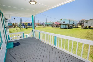 Guests can enjoy an outdoor space with a deck overlooking a lush lawn and surrounding homes.
