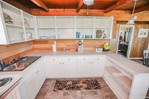 Enjoy cooking in this well-equipped kitchen with sink, stovetop, and ample storage.