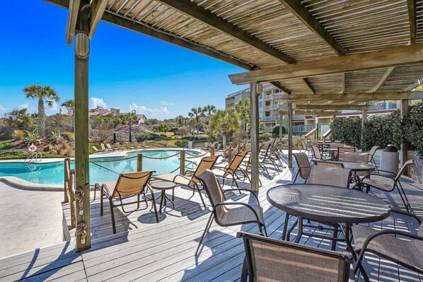 Relax by the pool in a serene outdoor space with a wooden deck and comfortable seating.
