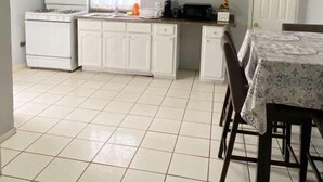 A kitchen with white cabinets, a stove, and a microwave. - Del Sol Medical Center Gem (El Paso)